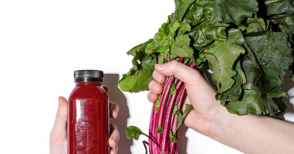 Person Holding a Bottle of Beetroot Juice and Beetroot in the other hand