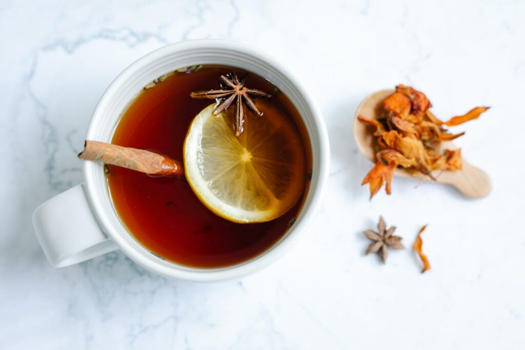 A bird's-eye view of a cup of cinnamon tea with a slice of lemon floating inside.