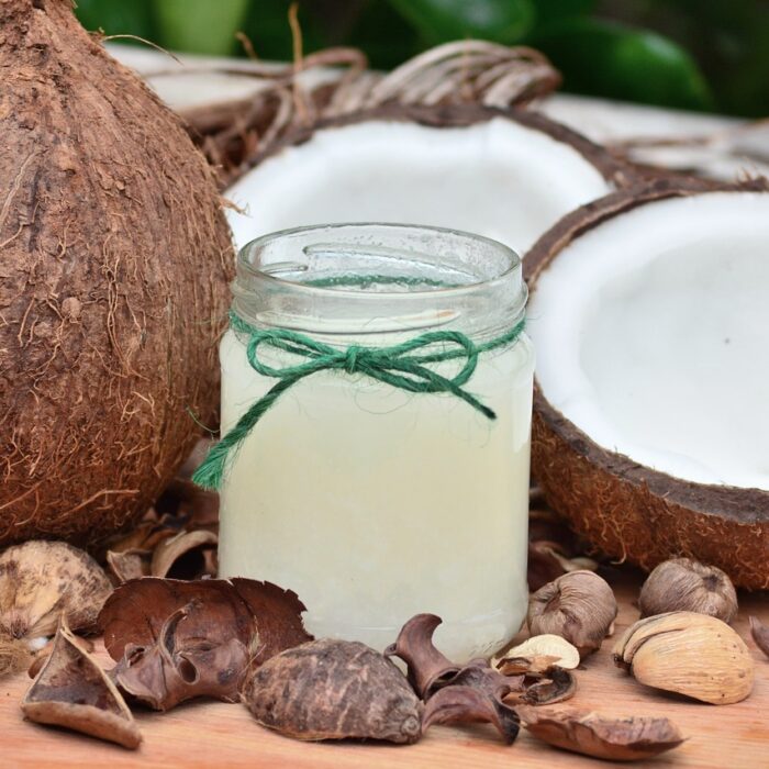 Jar of refreshing coconut water surrounded by open coconuts, highlighting natural hydration