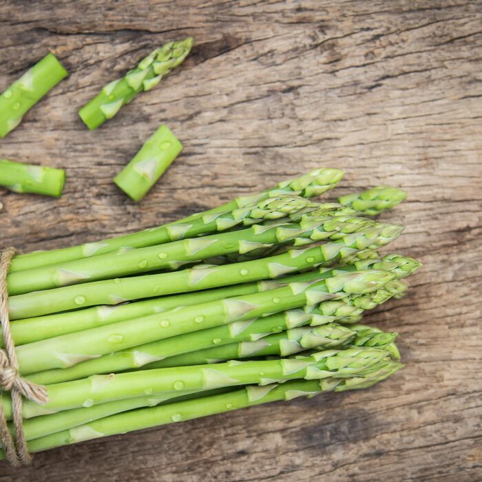 A bunch of Asparagus tied together on a table