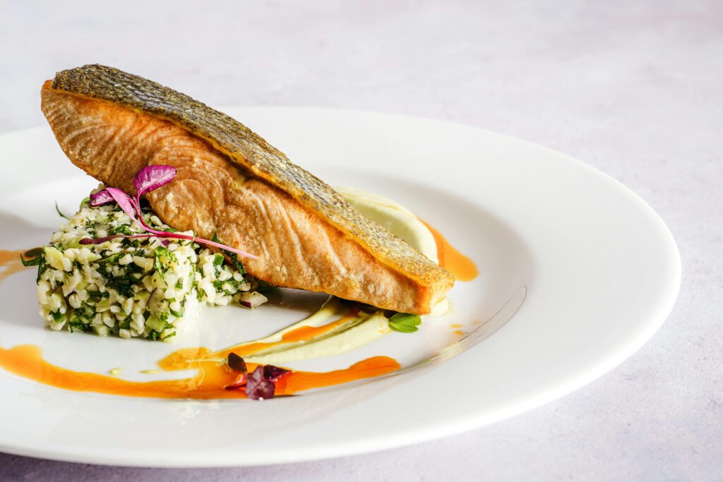 A plated salmon dish served with fresh ingredients.