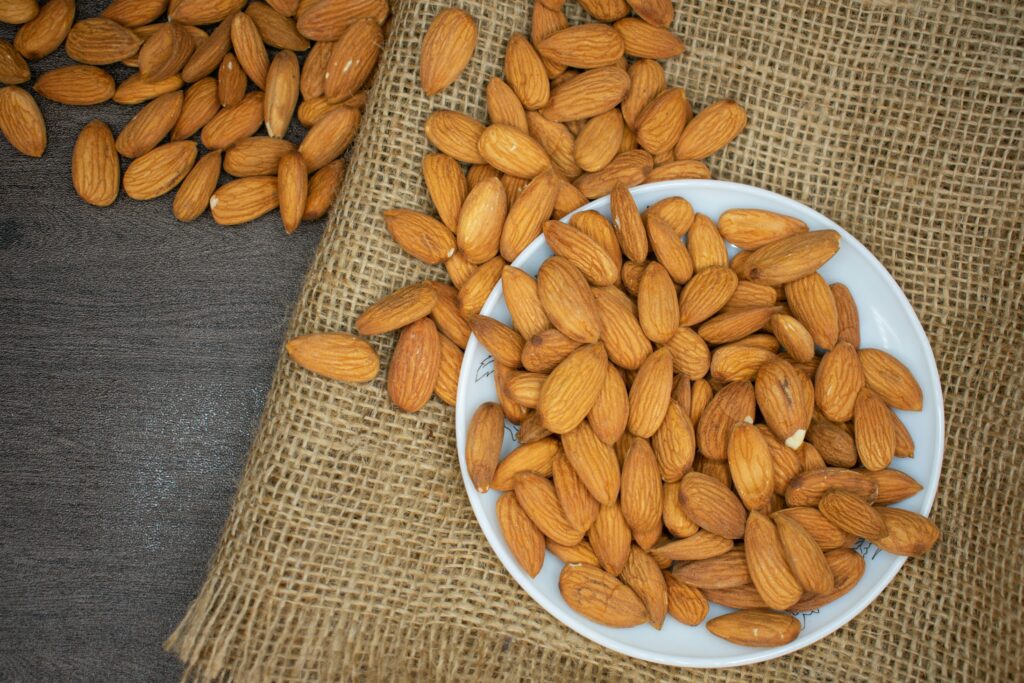 Almonds on a plate spilling on to a table