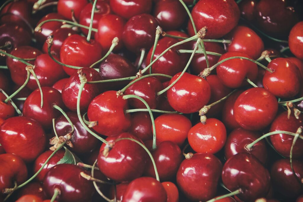 Close-up of fresh, vibrant cherries with glossy red skin.