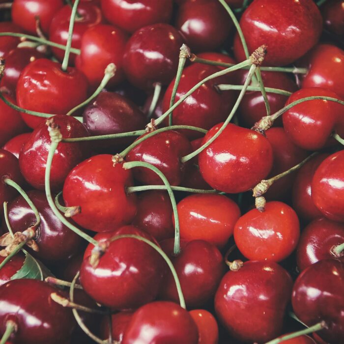 Close-up of fresh, vibrant cherries with glossy red skin.