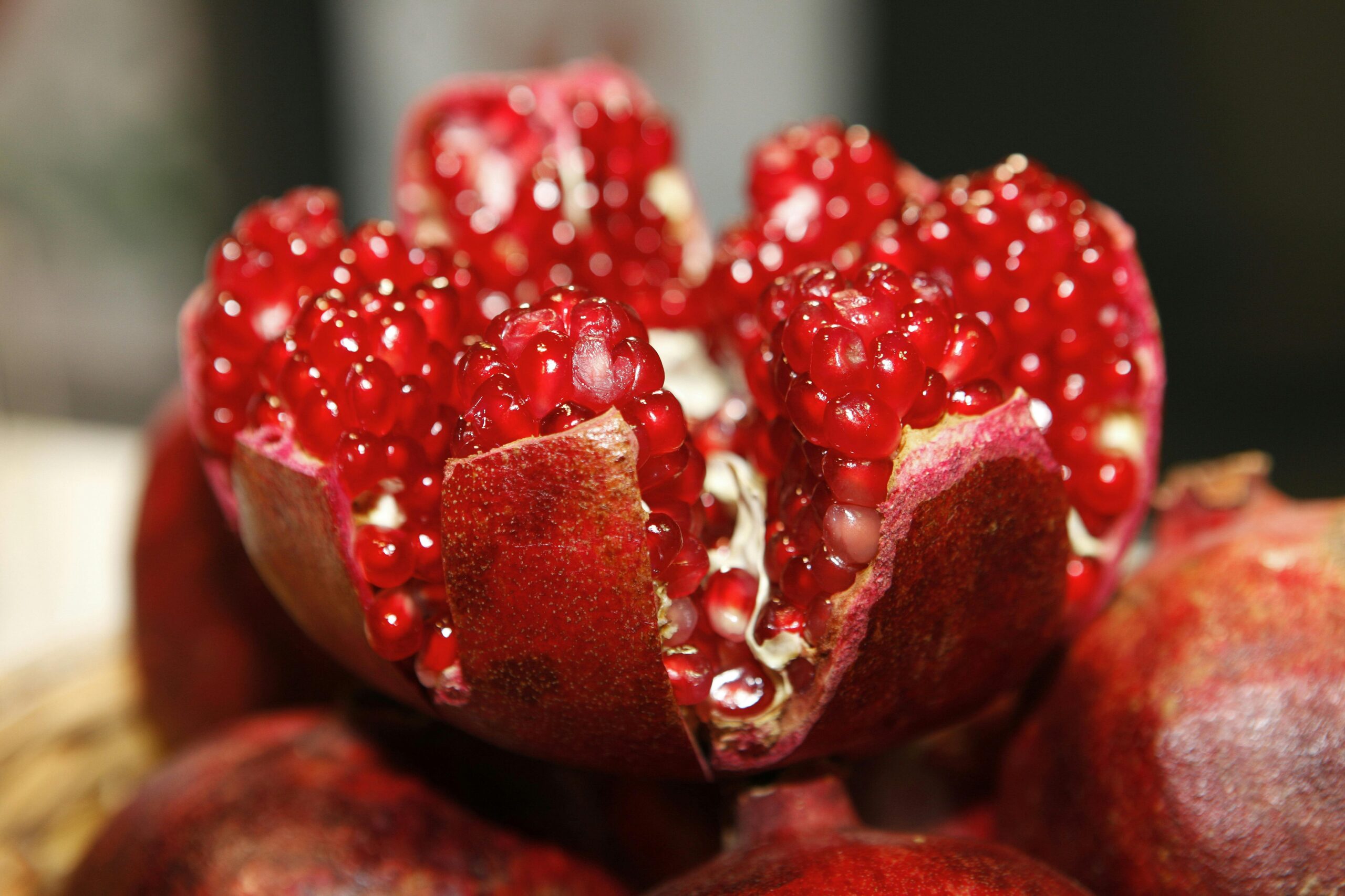 A split-open pomegranate showcasing its vibrant red seeds and colorful interior.